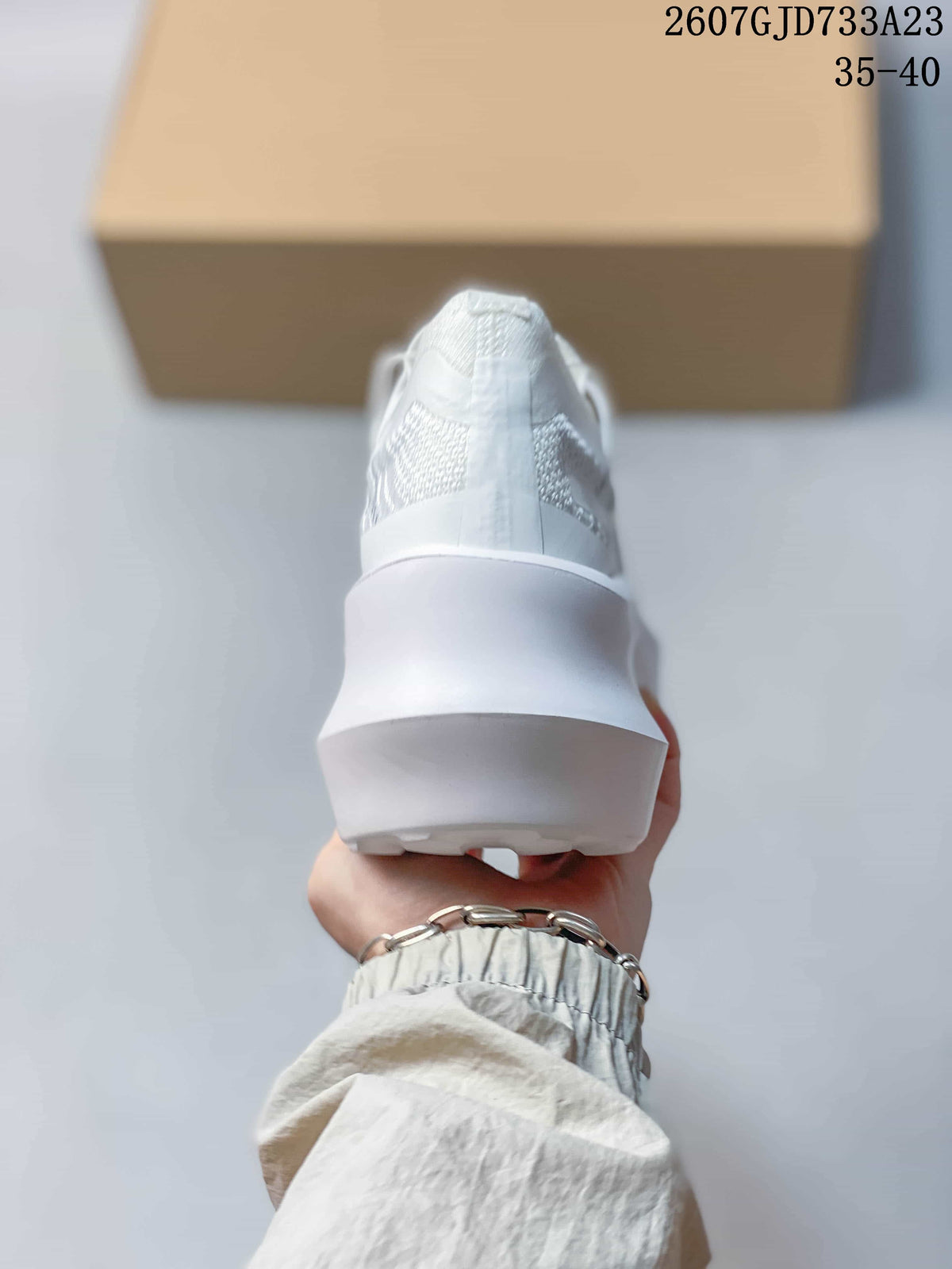 Rear view of the white sneaker showing the raised heel and thick sculpted sole.