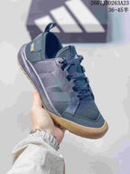 Single dark gray Adidas Terrex sneaker shown from the side with three-stripe panels, laces and a heel pull tab.