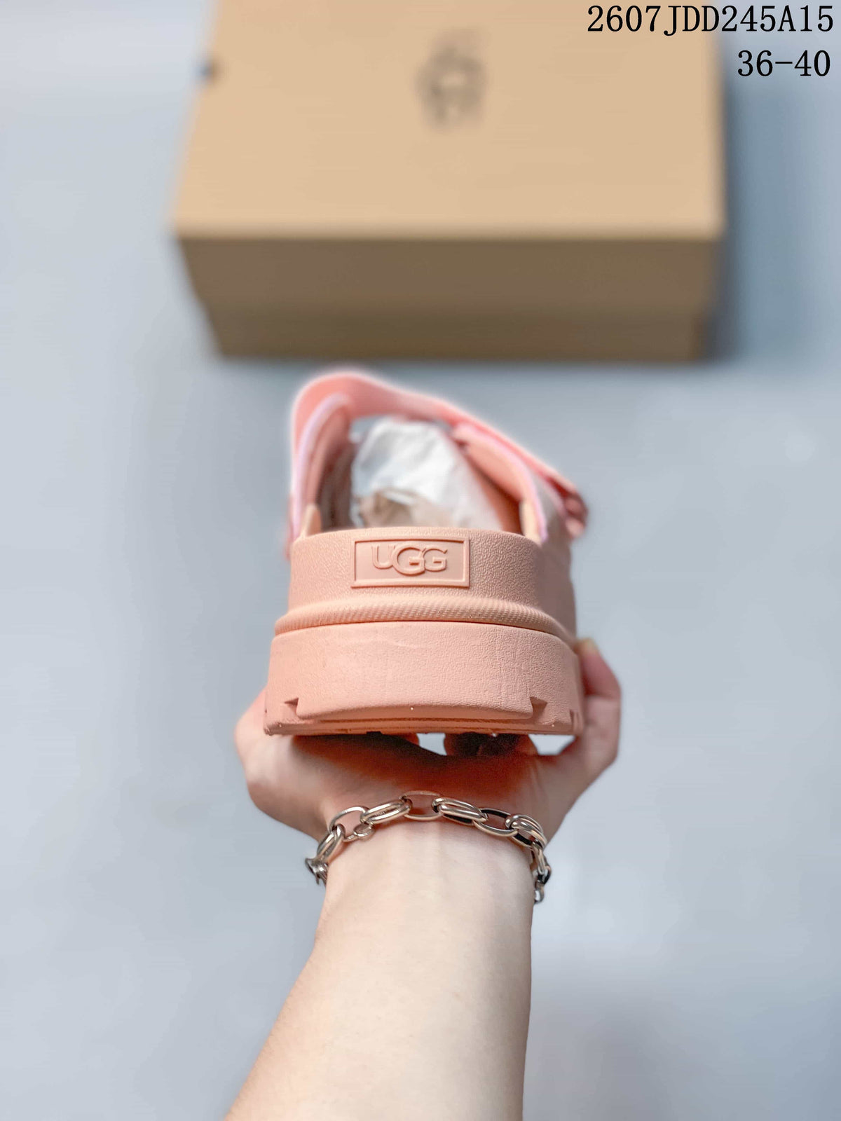 Rear view of the pink sandal showing the heel section and UGG logo plaque.