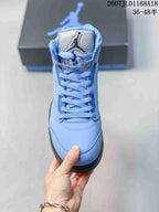 Front view of one light blue high-top sneaker showing the padded tongue, Jordan branding, laces and rounded toe.