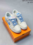 Pair of white and light blue Nike SB Dunk Low Pro sneakers displayed on an orange shoebox.
