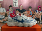 Side view of a Nike shoe with a dark blue swoosh, red collar, and speckled white sole.