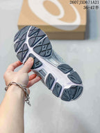 Close view of the sneaker outsole showing segmented dark tread sections and a light midsole; a shoe box is in the background.