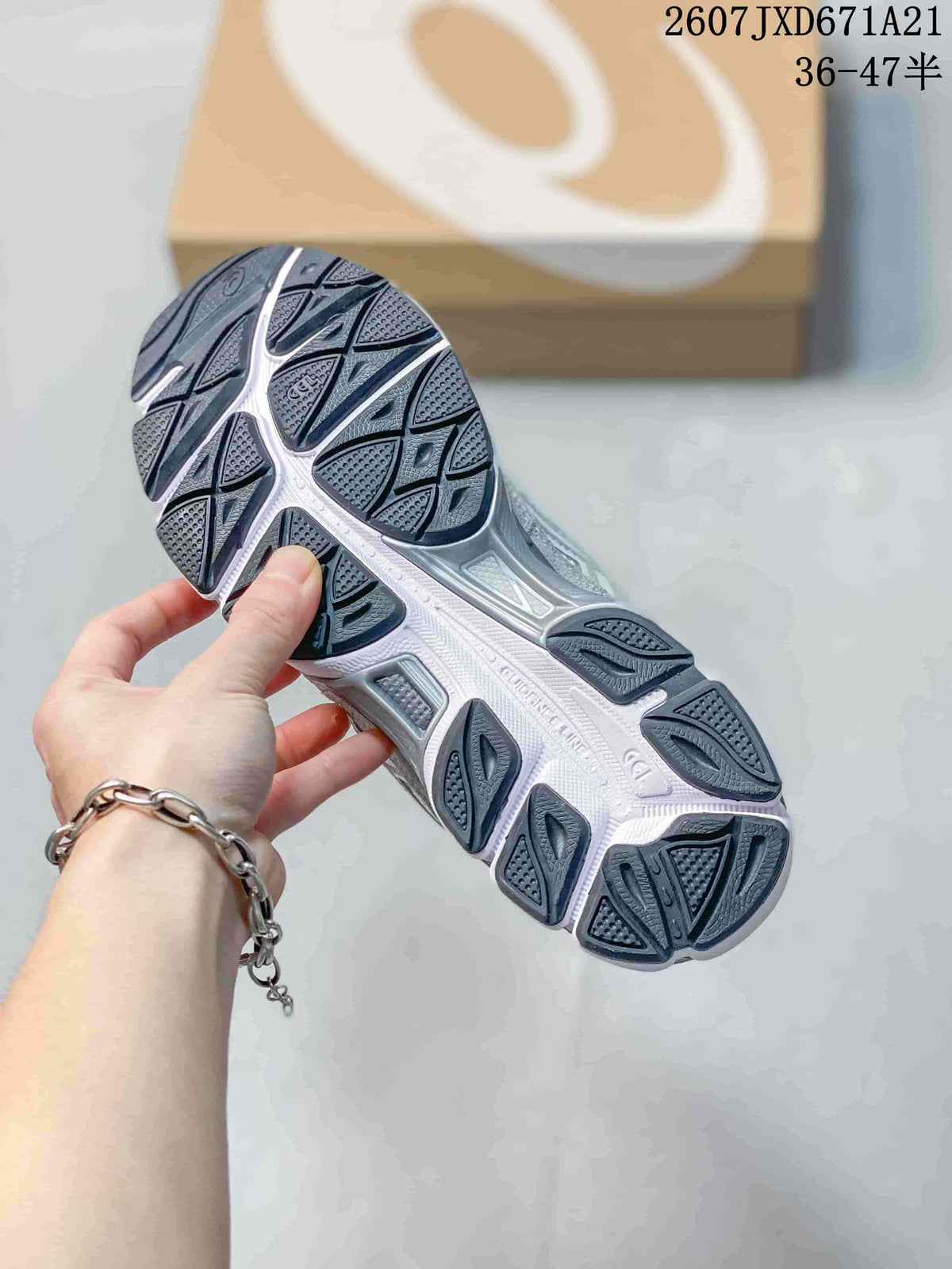 Close view of the sneaker outsole showing segmented dark tread sections and a light midsole; a shoe box is in the background.