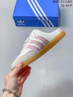 Side view of the white and pink Samba OG Mule sneaker with decorative side stripes and gum-colored outsole