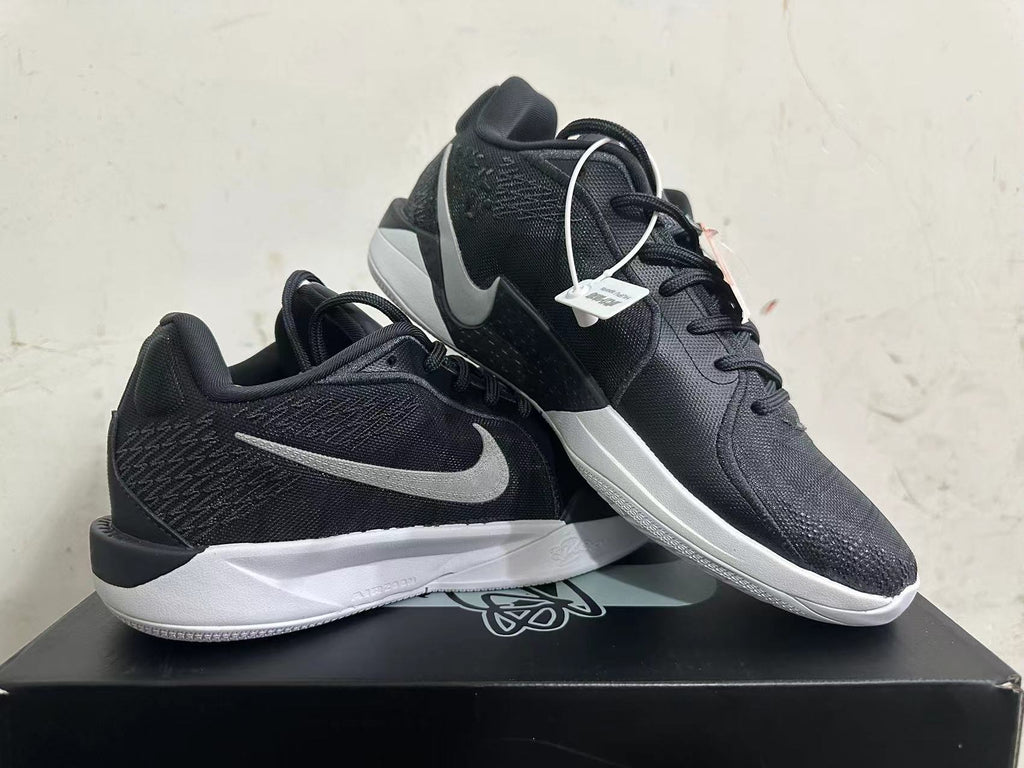 Pair of black low-top basketball shoes with silver-tone Swoosh and white midsoles