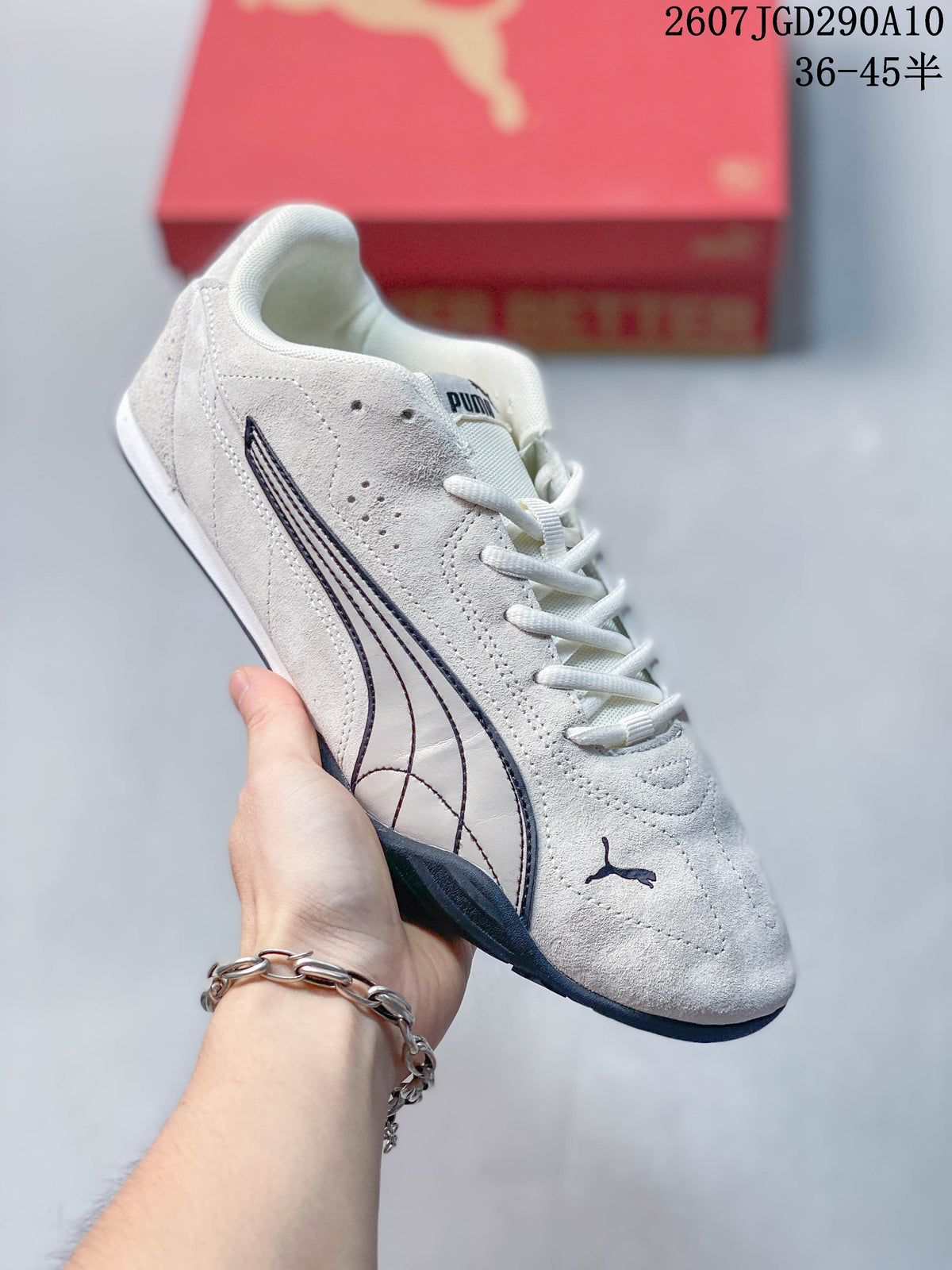 Angled side view of the white Puma sneaker with dark detailing, lace closure and low-profile sole.