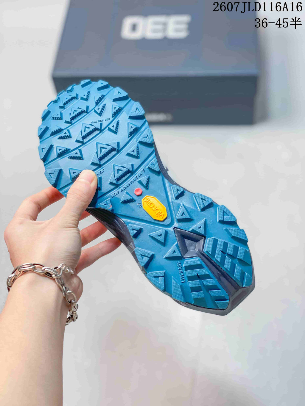 Close-up of the blue lugged outsole showing triangular tread blocks and a yellow outsole insert.