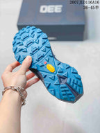 Close-up of the blue lugged outsole showing triangular tread blocks and a yellow outsole insert.