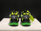 Rear view of the pair showing padded collars, black heel panels, neon green accents, and green outsole sections.