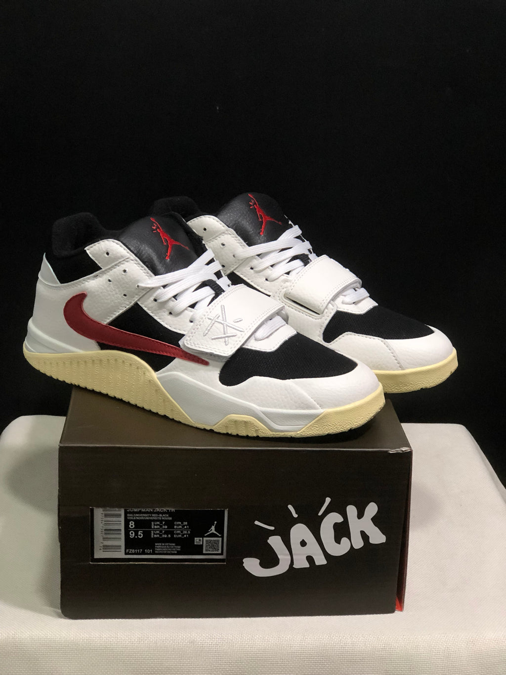 Pair of white, black, and red Jordan Jumpman Jack sneakers displayed on a branded shoe box.
