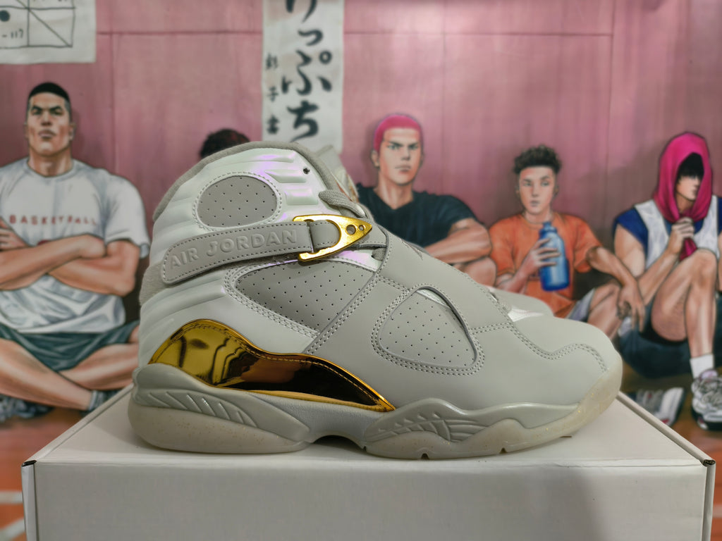 Side view of a light gray high-top sneaker with perforated panels and gold-tone accents