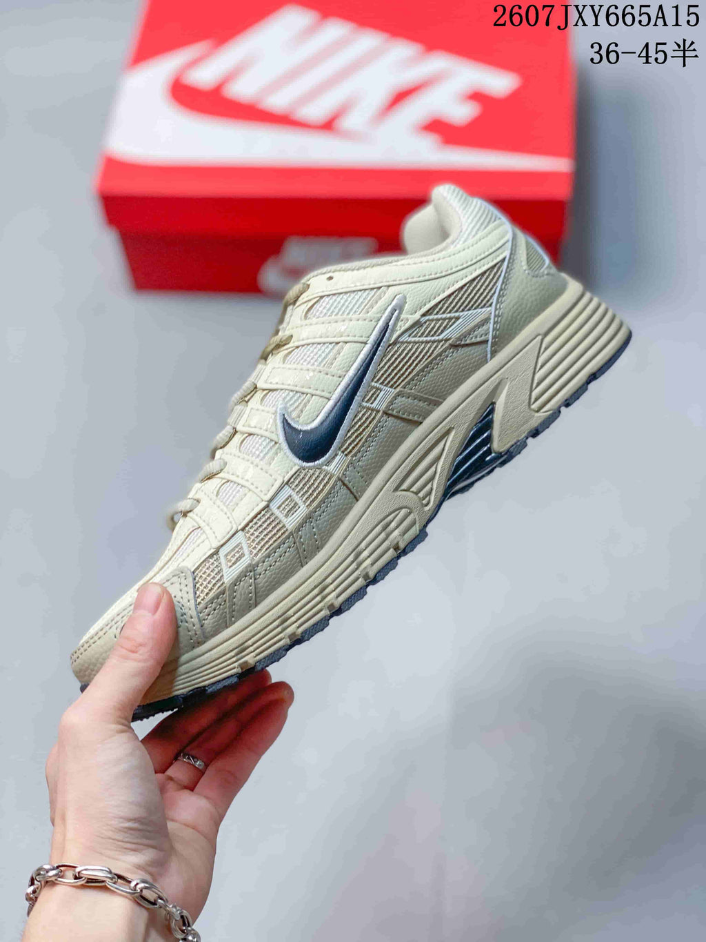 Side profile showing the cream layered upper, mesh panels, navy Swoosh, and sculpted midsole.