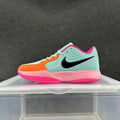 Side view of a low-top Nike basketball sneaker in mint, orange, pink, and black.