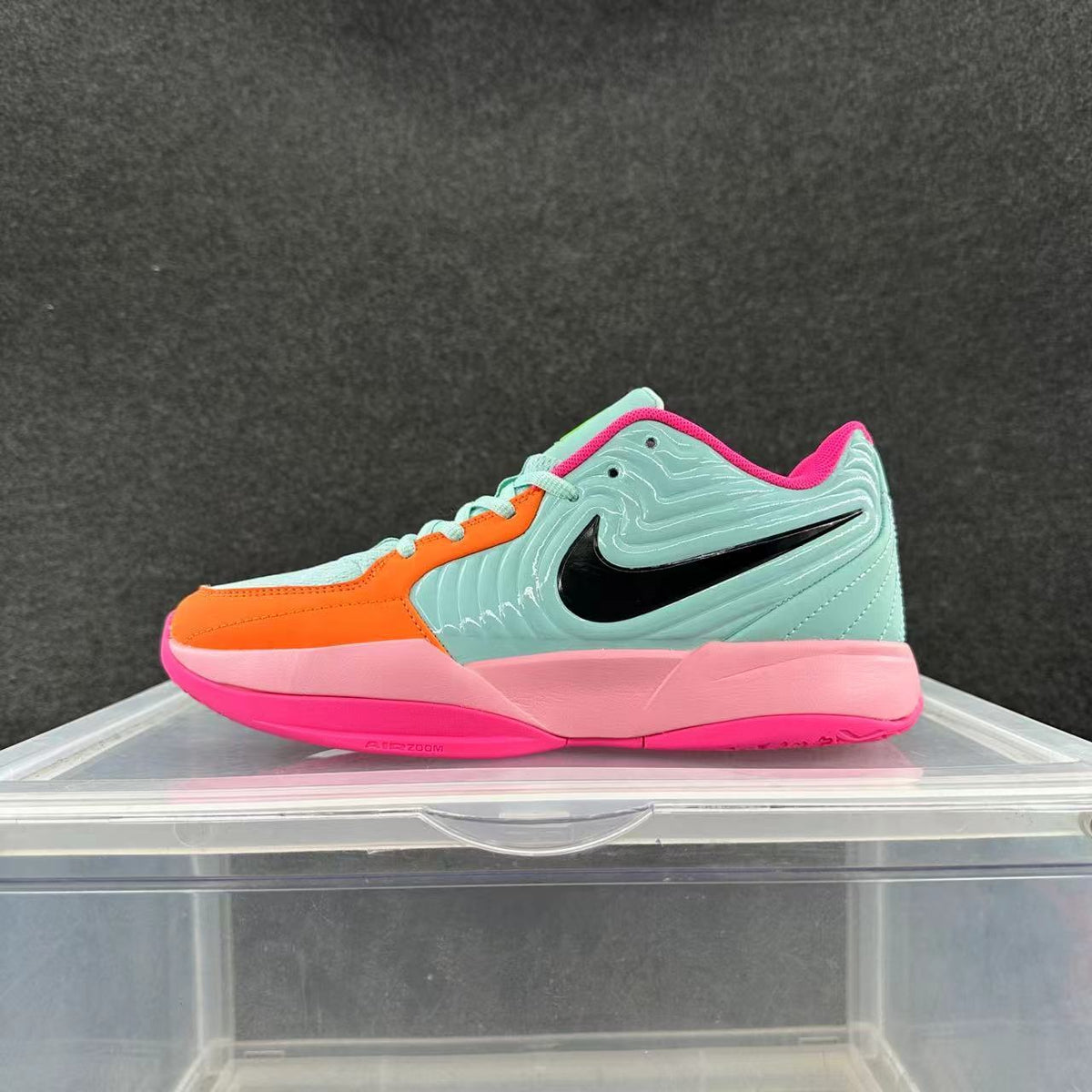 Side view of a low-top Nike basketball sneaker in mint, orange, pink, and black.