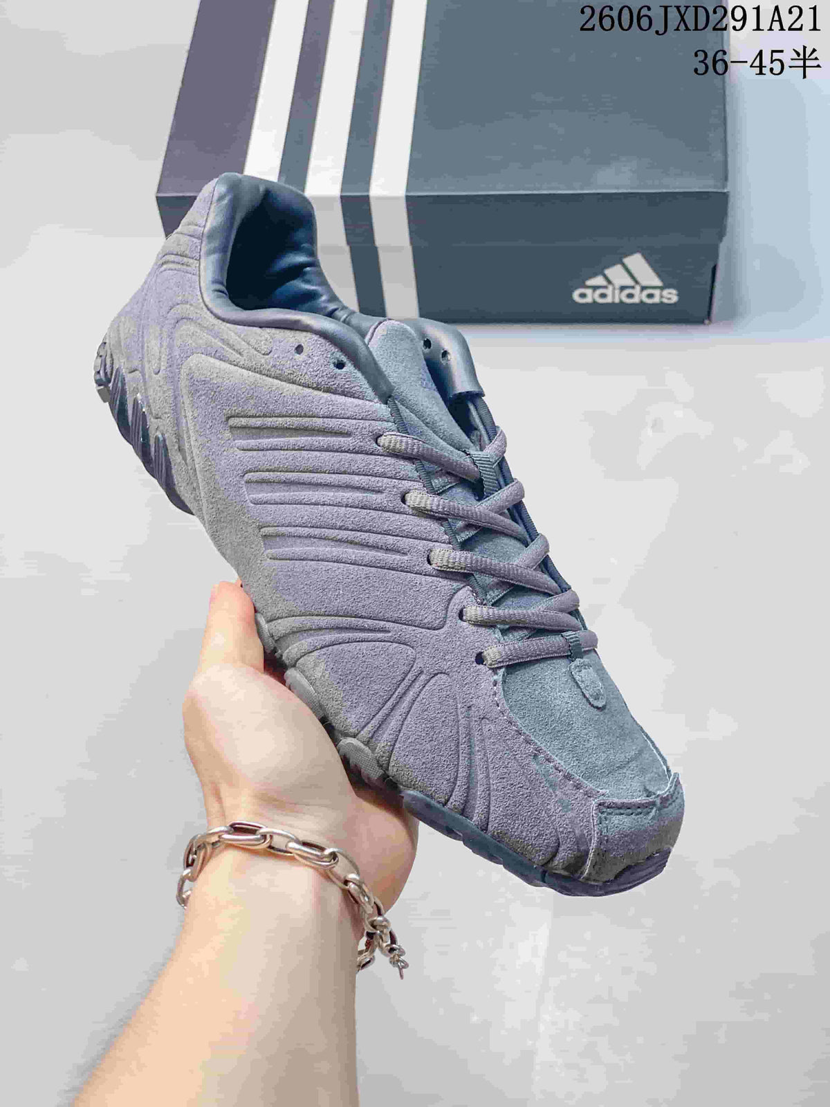 Angled front-side view of the gray adidas sneaker showing the streamlined upper and layered detailing.