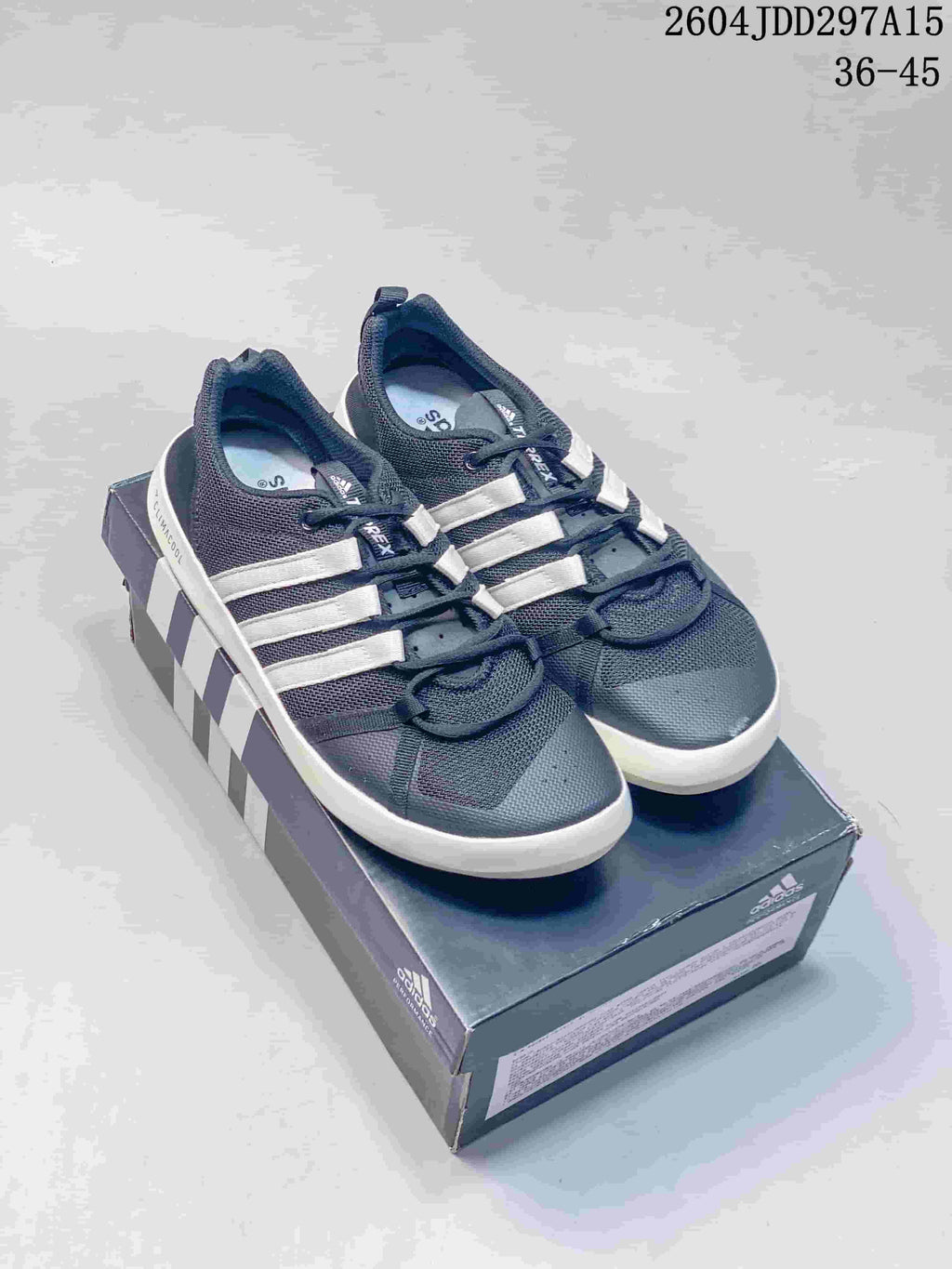 Pair of navy and white adidas Terrex CC Boat shoes displayed on an adidas shoe box; the image shows style code 2604JDD297A15 and size range 36–45.
