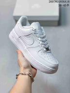 Angled side view of the white low-top sneaker showing the perforated toe box, stitched side panels, side detail, and textured outsole.