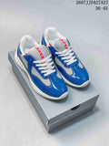 Pair of blue and white Prada America's Cup low-top sneakers displayed on a gray shoebox.