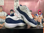 Two navy and white low-top sneakers displayed at an angle, showing the sides and outsoles.
