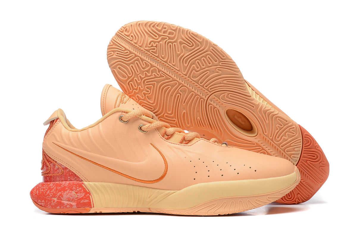 Peach Nike basketball shoes with coral accents and a matching patterned outsole.