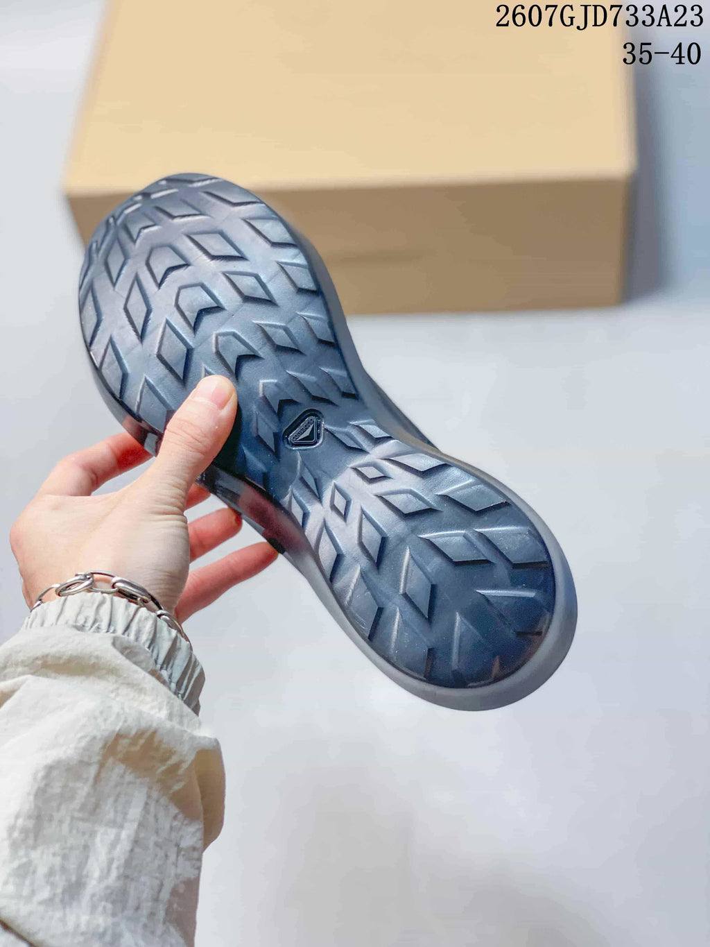 Close view of the sneaker outsole showing a raised directional tread pattern and Salomon logo detail.