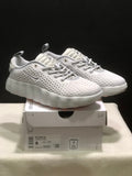 Pair of white Nike Mind 002 sneakers displayed on a product box, showing the perforated upper and sculpted sole.