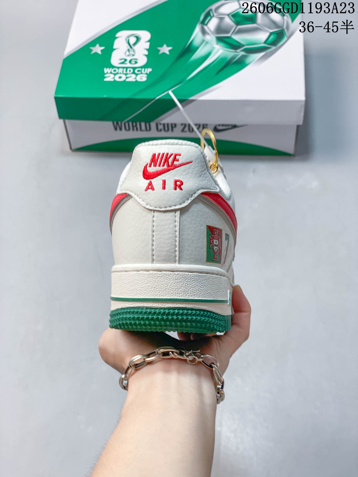 Rear view of the white sneaker showing red heel details and a green outsole.
