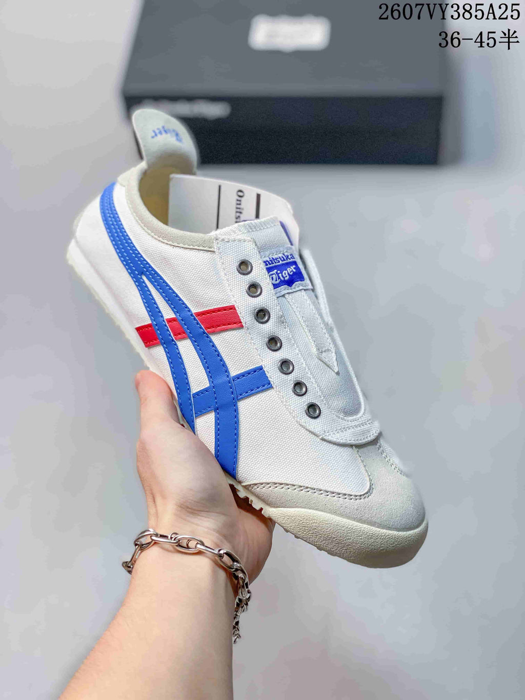 White slip-on sneaker with blue side stripes and a small red accent on the side.