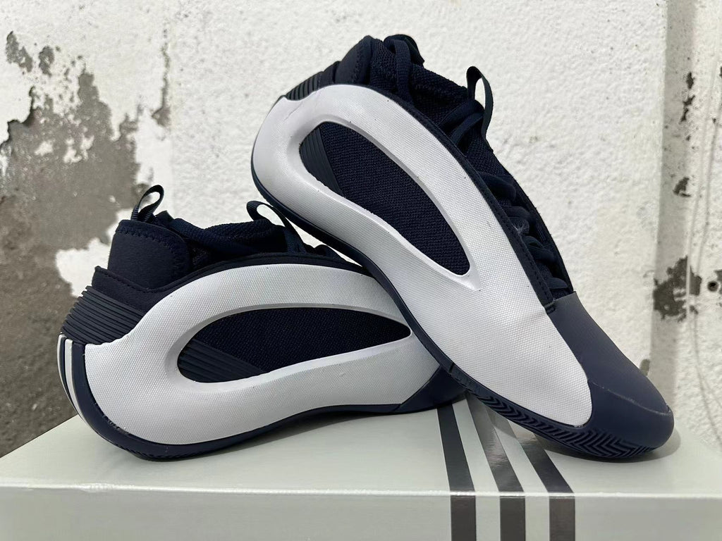 Navy and white Adidas basketball shoes displayed together, showing their side panels and outsole.
