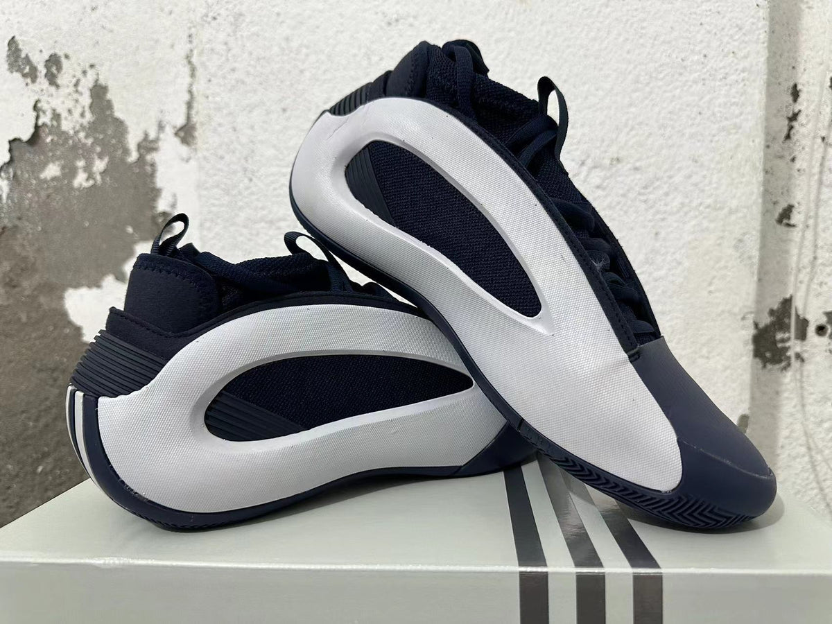 Navy and white Adidas basketball shoes displayed together, showing their side panels and outsole.