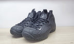 Pair of black Air Foamposite-style high-top sneakers shown from the front, with sculpted sides and white Swoosh details.