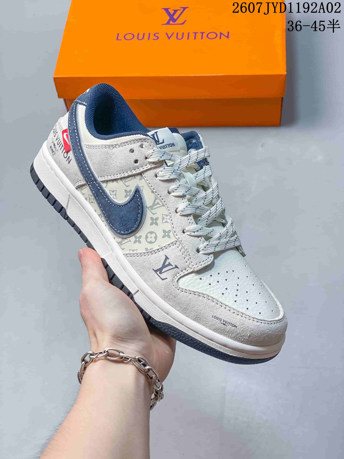 Hand-held side view of a white and navy low-top sneaker with perforated toe and patterned panels