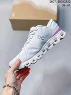 Side profile of the white and pink low-top sneaker showing the engineered knit-style upper, On logo, lace system, and segmented sole.