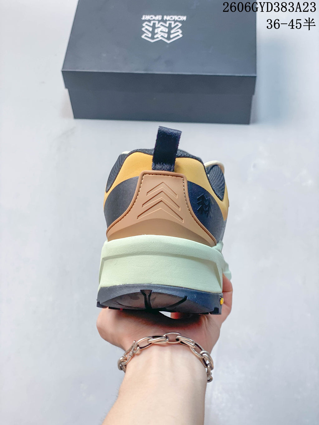 Rear view showing the heel panel, pull loop, and pale green midsole.