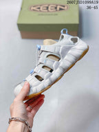 Side view showing the closed-toe sandal construction, open side panels, bungee lacing, and sculpted white midsole.