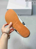 Close-up of the sneaker outsole showing a gum-colored sole with repeating wavy tread.