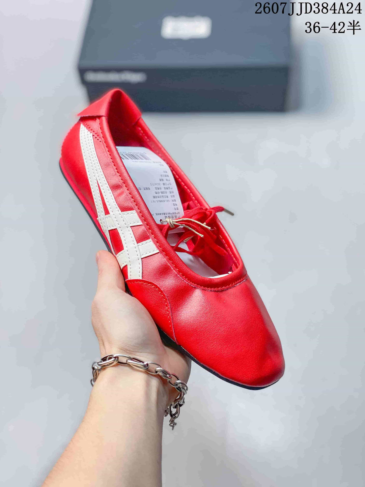 Angled view of the red shoe showing the white side stripes, lace-up Mary Jane-inspired upper, rounded toe, and low-profile sole.