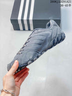 Side profile of the gray sneaker showing layered upper panels and the low-profile sole.