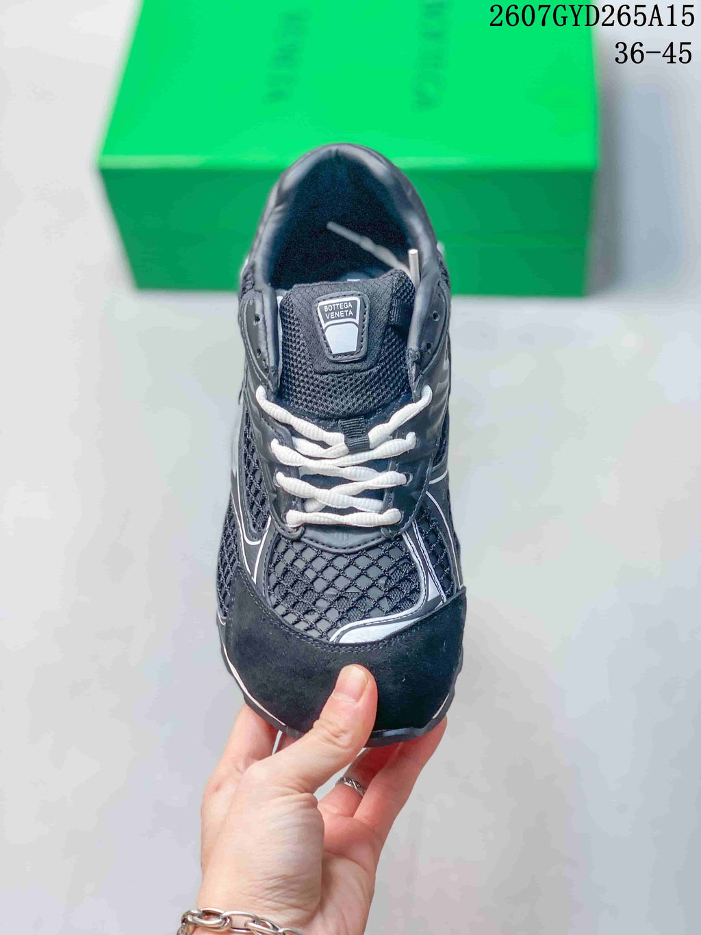 Front view of the sneaker showing white laces, padded tongue, mesh-style upper, and dark toe panel.
