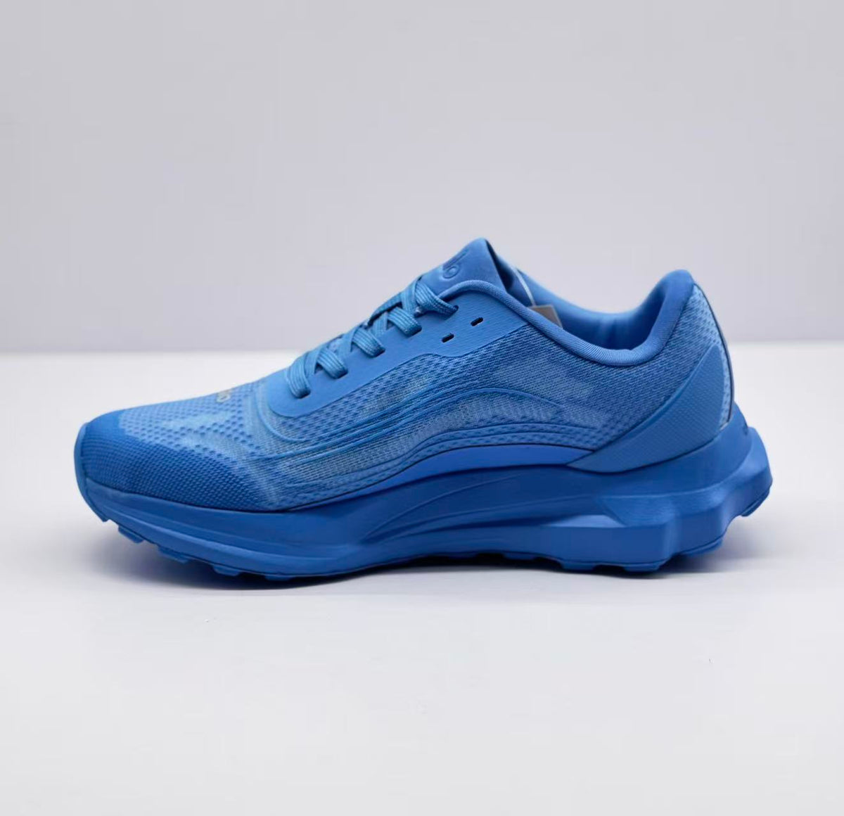 Opposite side view of the blue Alo Runner sneaker with tonal branding and textured upper.
