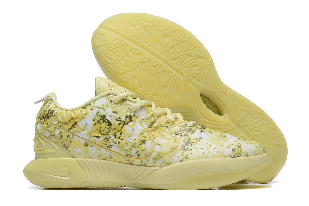 Pale yellow patterned Nike basketball shoe with a matching outsole.
