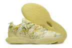 Pale yellow patterned Nike basketball shoe with a matching outsole.