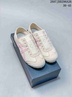 Pair of ivory and pink Onitsuka Tiger Mexico 66 Slip-On sneakers displayed on a shoe box.