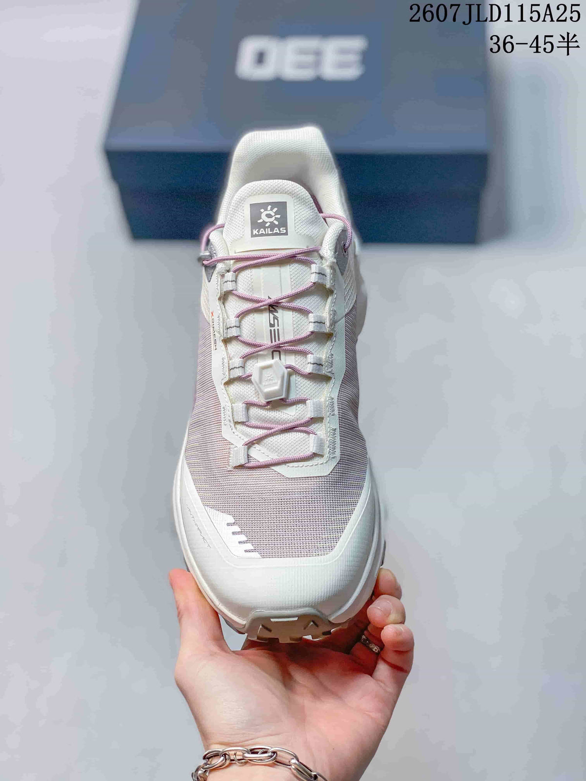 Front view of the white and lilac shoe showing the textured upper, purple quick-toggle laces, and KAILAS tongue label.