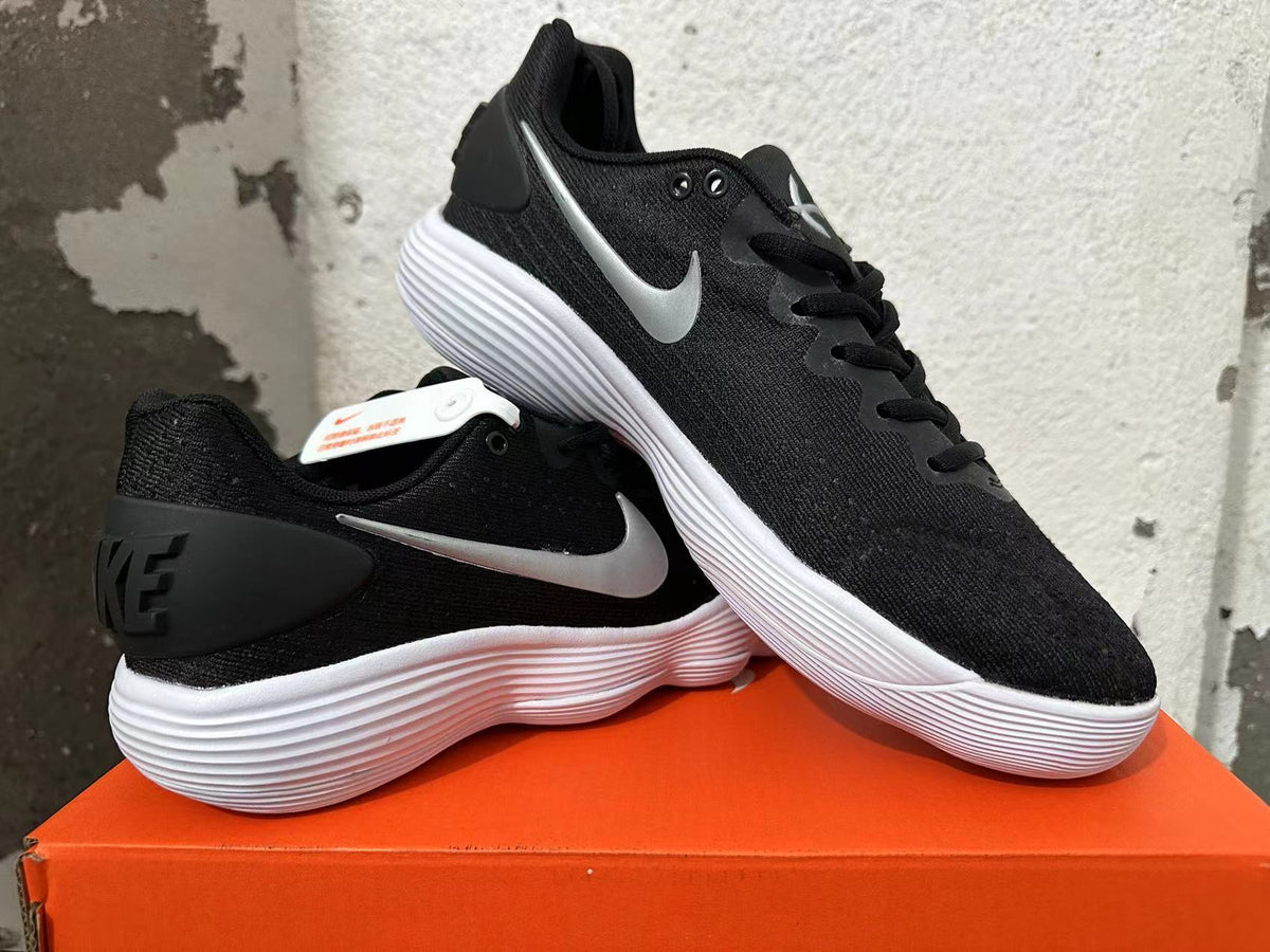 Pair of black Nike basketball shoes with silver Swooshes and white outsoles
