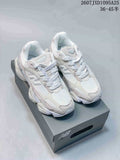 Pair of light white and cream New Balance 9060R sneakers displayed on a shoe box.
