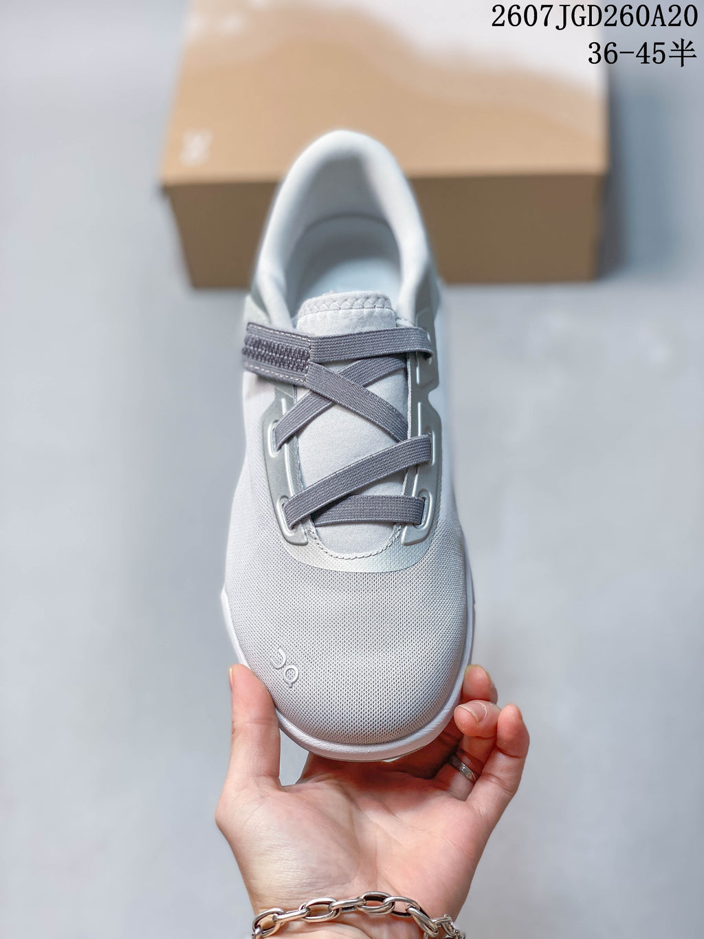 Top view of the sneaker showing the rounded toe, gray crossed straps, padded tongue, and On logo.