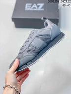 Side view of the gray sneaker showing mesh panels, tonal overlays, lace-up construction, and a ridged outsole.