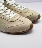 Close-up of the beige textured upper, white laces and brown toe outsole.